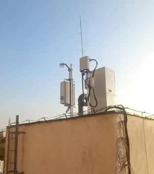 Antenna mast and equipment enclosures on a rooftop